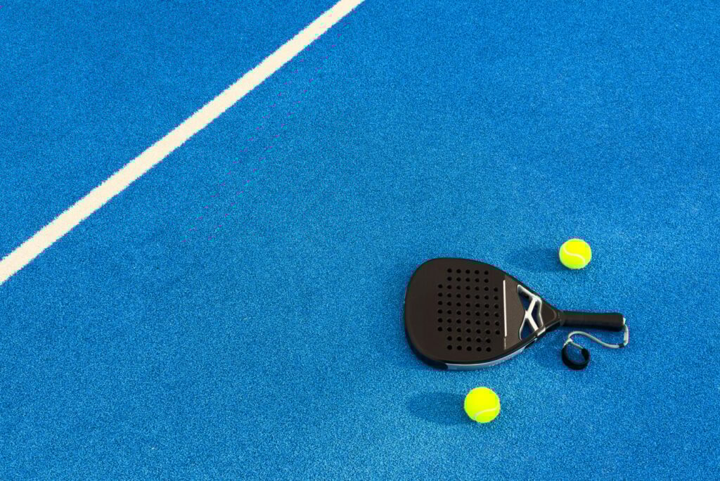 Padel tennis racket. Background with copy space. Sport court and balls.